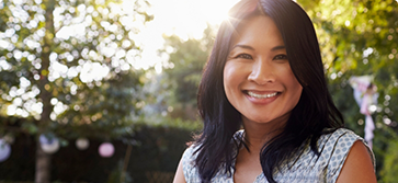 Woman with straight dark hair smiling in the sun