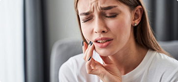 Woman holding the side of her jaw in pain
