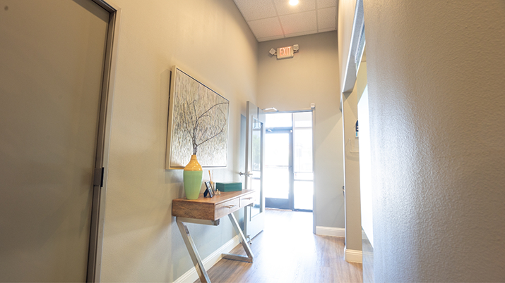 View from the hallway of sunlight streaming in through the window of the front door of Parklane Family Dentistry